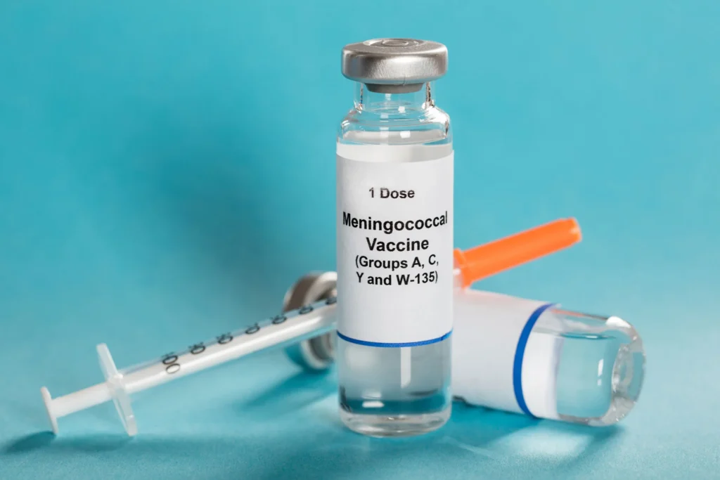 Vial labeled “Meningococcal Vaccine” with syringe and another vial against turquoise background.